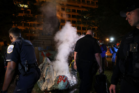 الشرطة تحاول اطفال النيران فى التمثال