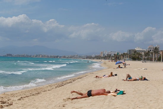 مواطنون يحصلون على حمام شمس بأحد الشواطئ