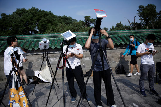 وسائل الاعلام تتابع كسوف الشمس من بكين