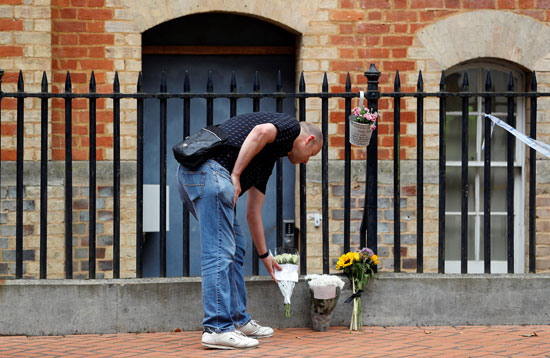 رجل يضع الزهور بجوار طوق الشرطة فى موقع الحادث