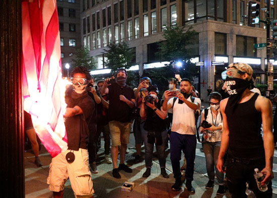 متظاهرون يحرقون علم أمريكا بواشنطن