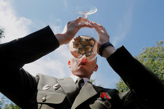 خريج يشرب الشمبانيا وهو يحتفل بعد حصوله على دبلوم في الأكاديمية العسكرية في روسيا البيضاء