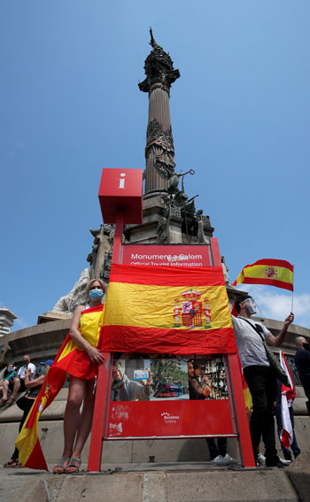 المتظاهرون يرفعون علم إسبانيا ولافتات ضد العنصرية