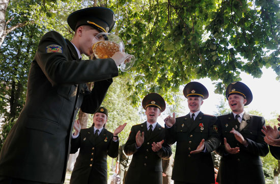 خريج يشرب الشمبانيا بعد حصوله على دبلوم في الأكاديمية العسكرية في روسيا البيضاء