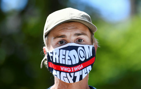 متظاهر يرتدي قناع وجه خلال احتجاج ضد تدابير الحكومة