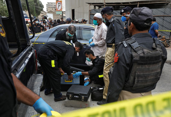 أعضاء وحدة مسرح الجريمة في شرطة كراتشي يستعدون لمسح موقع هجوم في بورصة باكستان في كراتشي