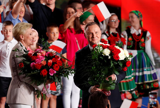 أندريه دودا رئيس بولندا وزوجته يحملان الورود