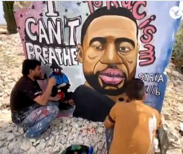 سوريون يرسمون جدارية لجورج فلويد