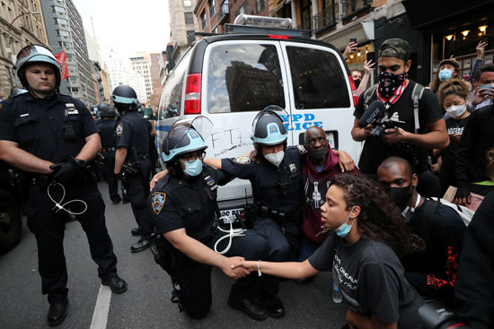 رجال الشرطة يمدون يدهم لتحية متظاهرين فى نيويورك