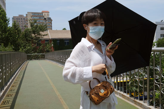 سيدة ترتدى الكمامة فى شوارع بكين