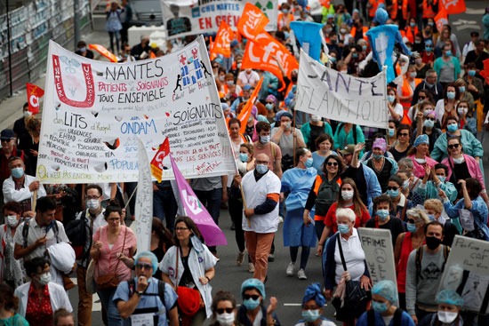 العاملون بالقطاع الصحى فى فرنسا يرفعون لافتات خلال تظاهرهم