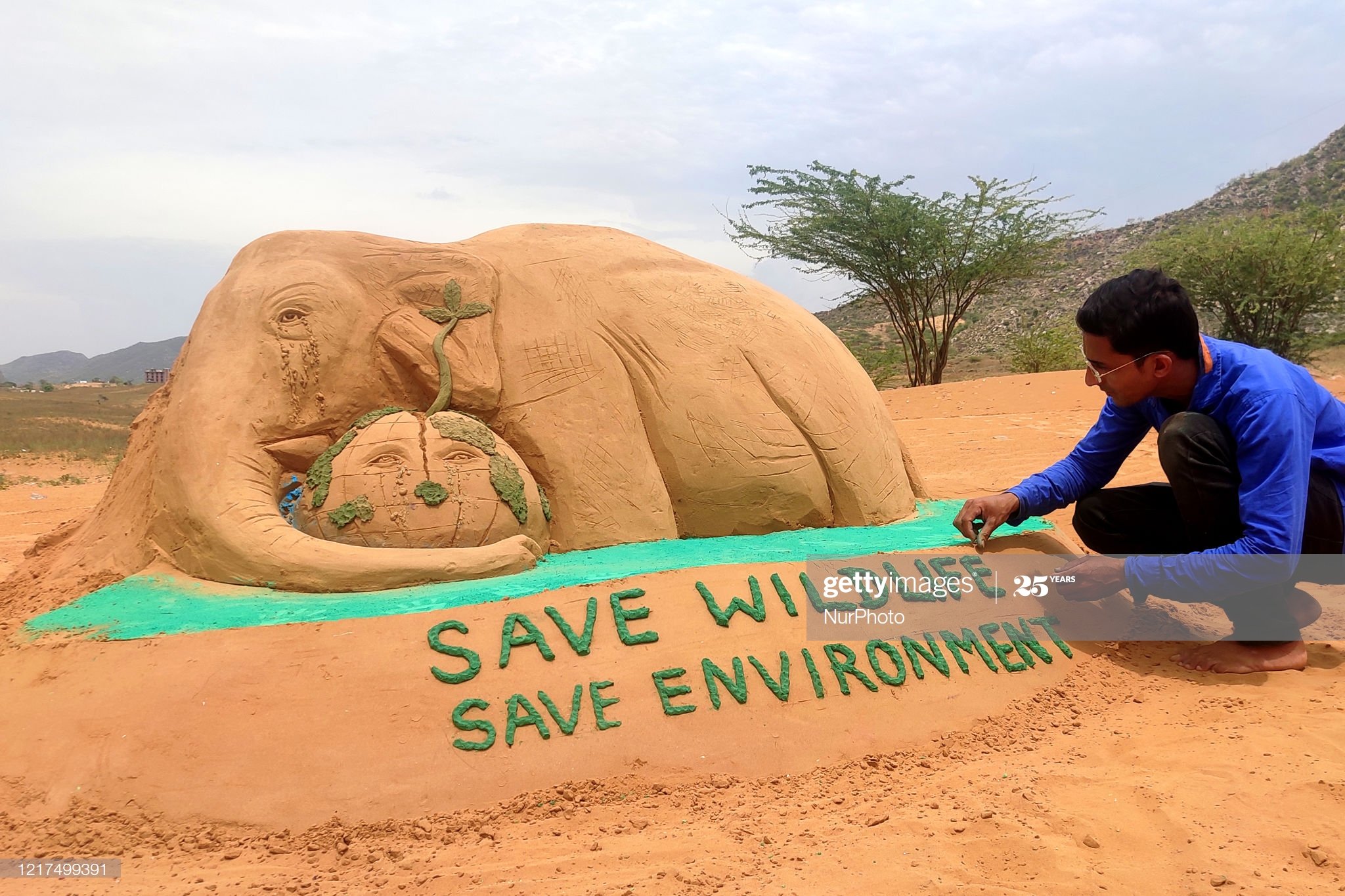 رسام هندي يرسم الفيل من الرمال