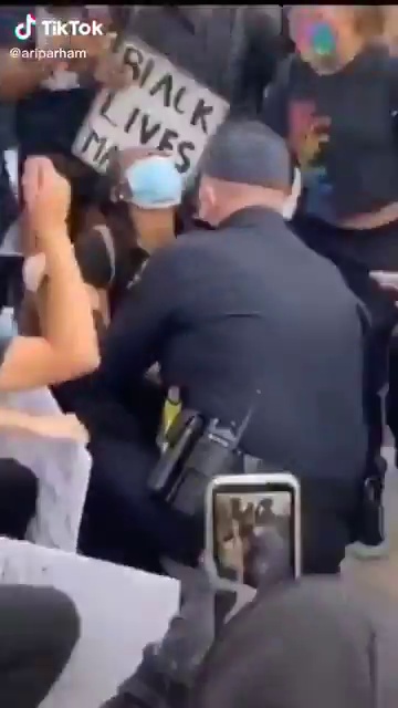شرطي أمريكي أبيض ينحني لـ حبيبته السمراء وسط المتظاهرين (2)