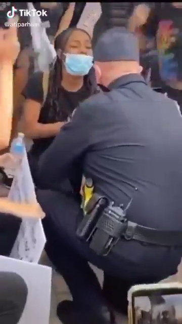 شرطي أمريكي أبيض ينحني لـ حبيبته السمراء وسط المتظاهرين (4)