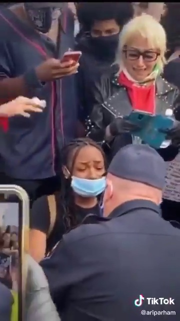 شرطي أمريكي أبيض ينحني لـ حبيبته السمراء وسط المتظاهرين (6)