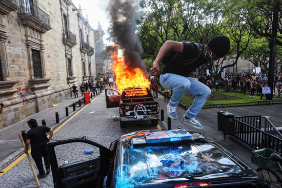 متظاهر مكسيكى يدمر سيارة للشرطة