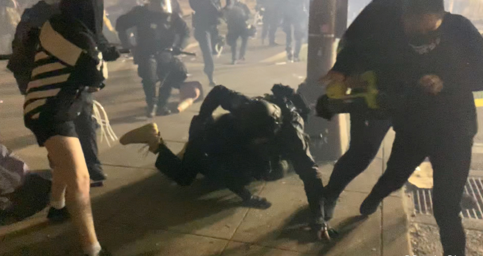 شرطى يحاول القبض على أحد المتظاهرين فى بورتلاند