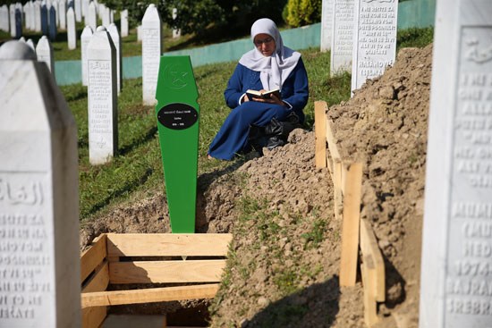 سيدة تقرأ القرآن بجوا قبر فقيدها