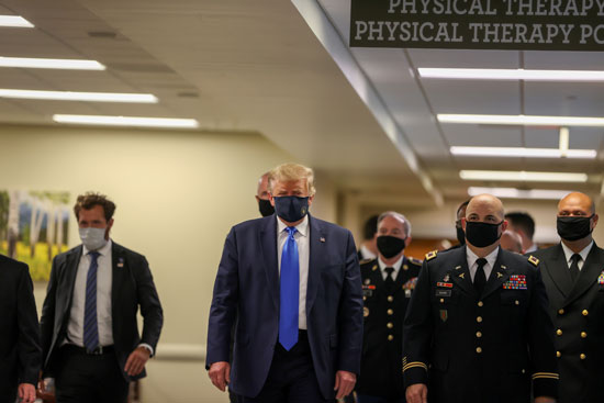 ترامب يرتدى الكمامة داخل المركز الطبى