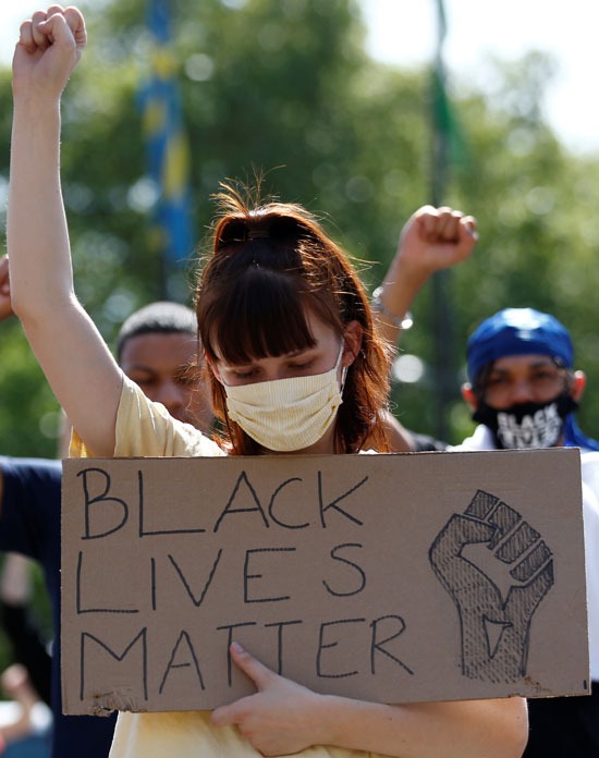 يشارك متظاهر يرتدي قناع وجه في احتجاج على مسألة الحياة السوداء في ماربل آرتش ، في لندن