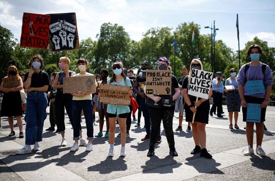 متظاهرون يرتدون أقنعة الوجه يحملون لافتات خلال احتجاجات حياة سوداء في ماربل آرتش