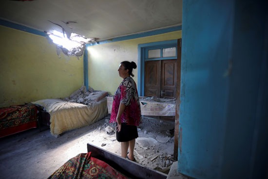 سيدة تقف وسط منزلها المتضرر فى أرمينيا