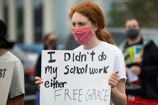 طالبة تحمل لافتة مناهضة لإعادة الدراسة