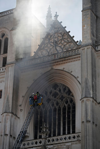 رجال الإطفاء يحاولون السيطرة على الحريق المشتعل بمبنى الكاتدرائية