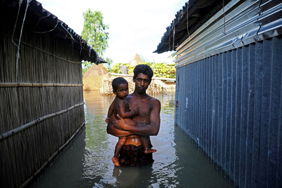 رجل يلتقط صورة تذكارية وسط مياه الفيضانات
