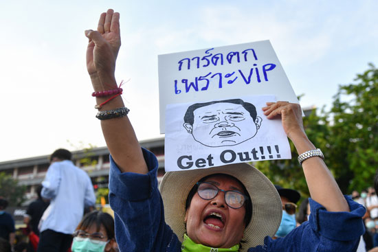 متظاهرة تحمل صورة ساخرة لملك تايلاند.. وتطالب بخروجه من القصر