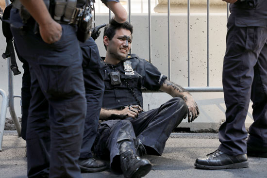 ضابط  يحتجز متظاهرًين بعد تلطيخ جداريةحياة سودا خارج برج ترامب     (2)