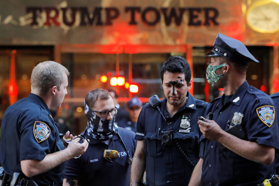 ضابط  يحتجز متظاهرًين بعد تلطيخ جداريةحياة سودا خارج برج ترامب     (1)