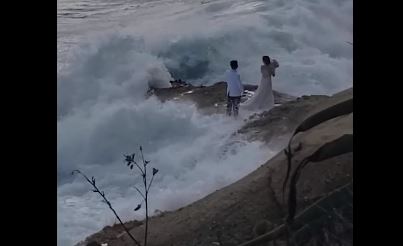 جلسة تصوير عروسين تحولت إلى كابوس بسبب الأمواج في أمريكا.. فيديو (1)