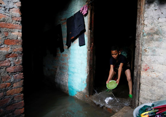 طفل من النيبال يتخلص من المياه الموجودة داخل المنزل