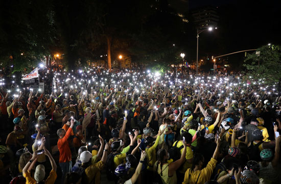 متظاهرون يحملون هواتف محمولة مضاءة أثناء الاحتجاجات