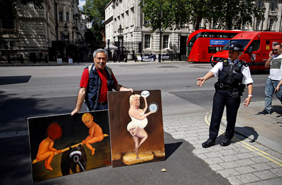 فنان يحمل لوحات ساخرة ضد وزير الخارجية الأمريكى