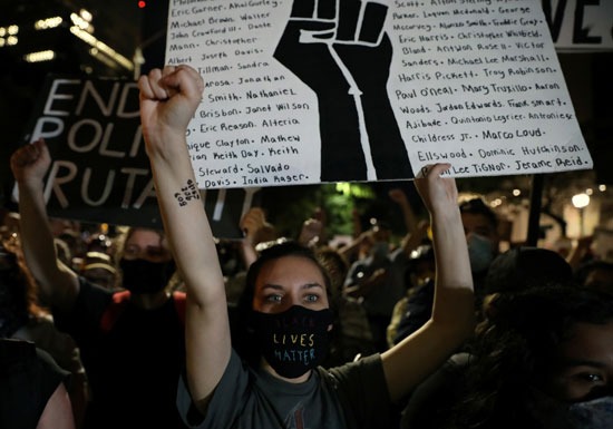 المتظاهرون يحملون لافتات ويرفعون قبضاتهم خلال الاحتجاجات
