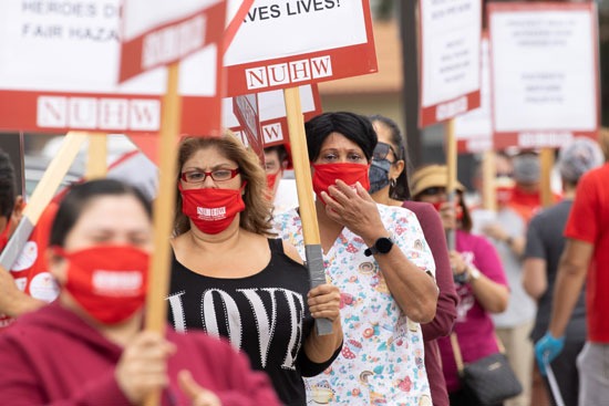 العاملات في المستشفى يرفعن اللافتات رفضًا لنقص الرعاية الطبية