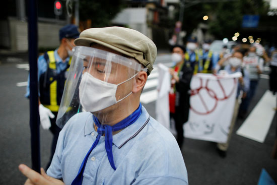 متظاهر يرتدي قناع وجه خلال الاحتجاج