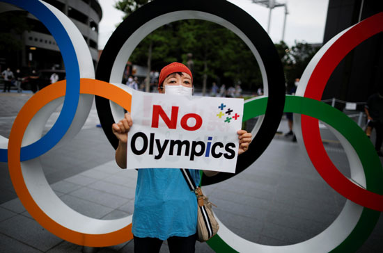 متظاهرة تحمل لافتة ضد أولومبياد 2020