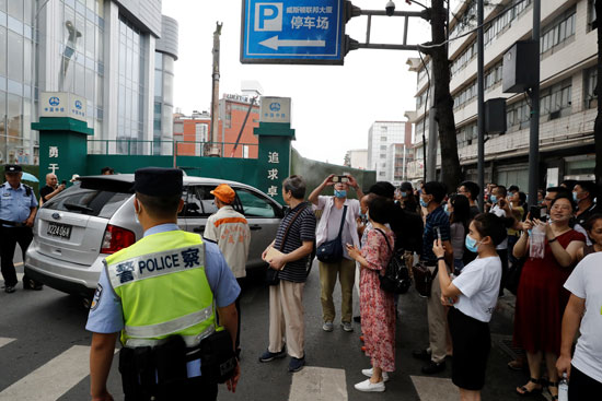 مواطنون صينيون يتابعون مغادرة سيارة السفارة الأمريكية في تشغندو