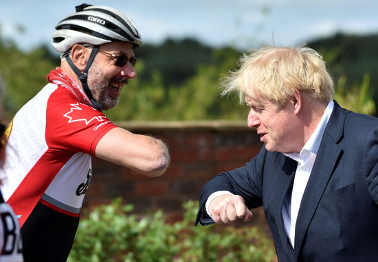 رئيس الوزراء البريطاني يصافح راكبي الدراجات
