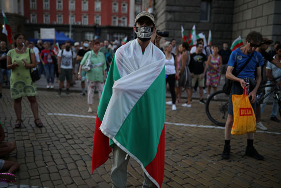 متظاهر يغطى نفسه بعلم بلاده متظاهر يغطى نفسه بعلم بلاده