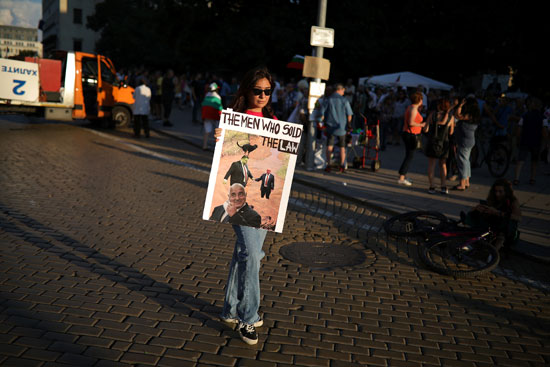 متظاهرة تحمل صوره ساخرة لرئيس الحكومة