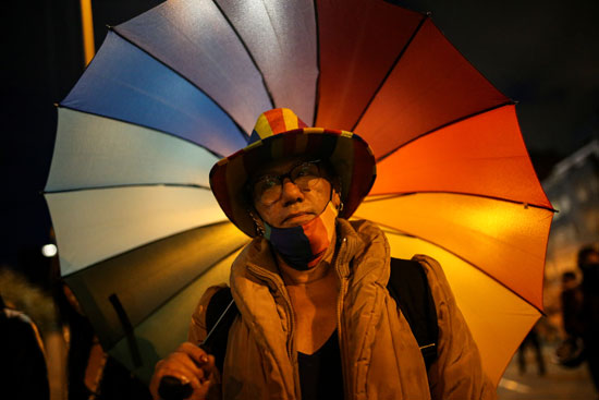 محتج يحمل شمسية  بألوان قوس قزح