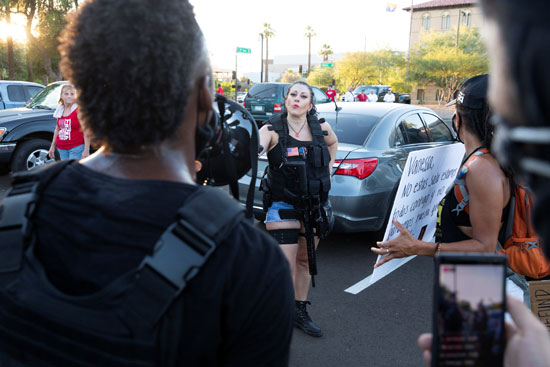 سيدة تحمل السلاح النارى فى مظاهرة بولاية أريزونا