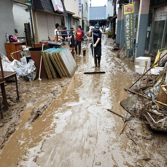 ينظفون شارعًا موحلًا بعد هطول أمطار غزيرة في هيتويوشي محافظة كوماموتو (1)