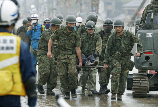 جنود من قوات الدفاع الذاتي اليابانية يحملون شخصًا تم إنقاذهم