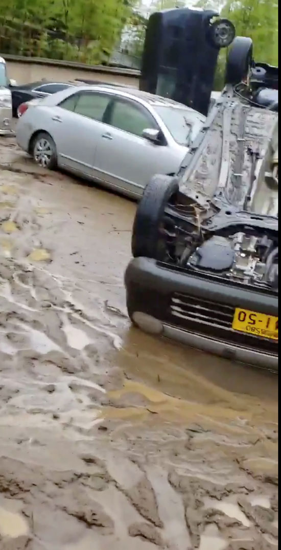 المياه الموحلة عبر منطقة سكنية قرب  نهر كوما بعد تهديد أمطار غزيرة غير مسبوقة بالفيضانات
