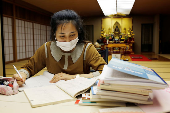عاملة فيتنامية تدرس اللغة اليابانية بالمعبد